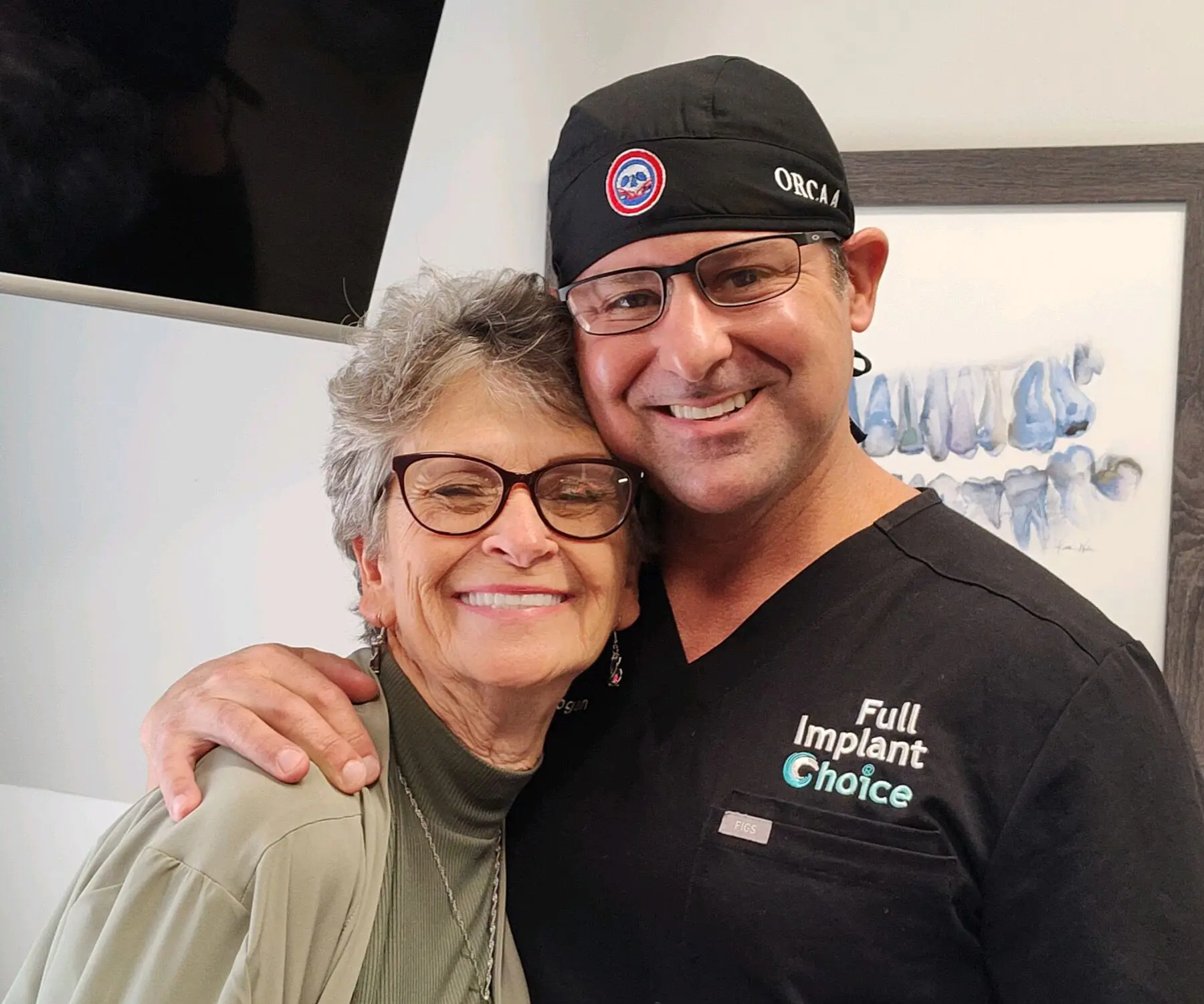 Dr. Hogan hugging a smiling Full Implant Choice patient after treatment